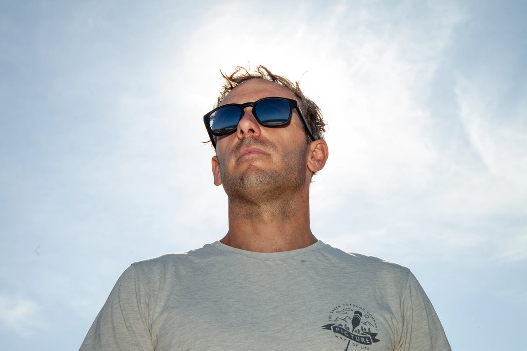 Estran Bapt à la plage portant les lunettes de soleil 2ndlife Estran