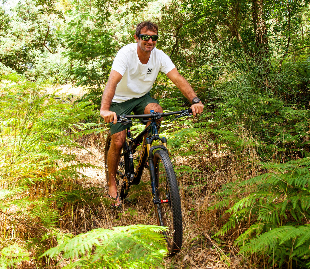 Jo de face à vélo dans la forêt portant des lunettes de soleil 2ndlife