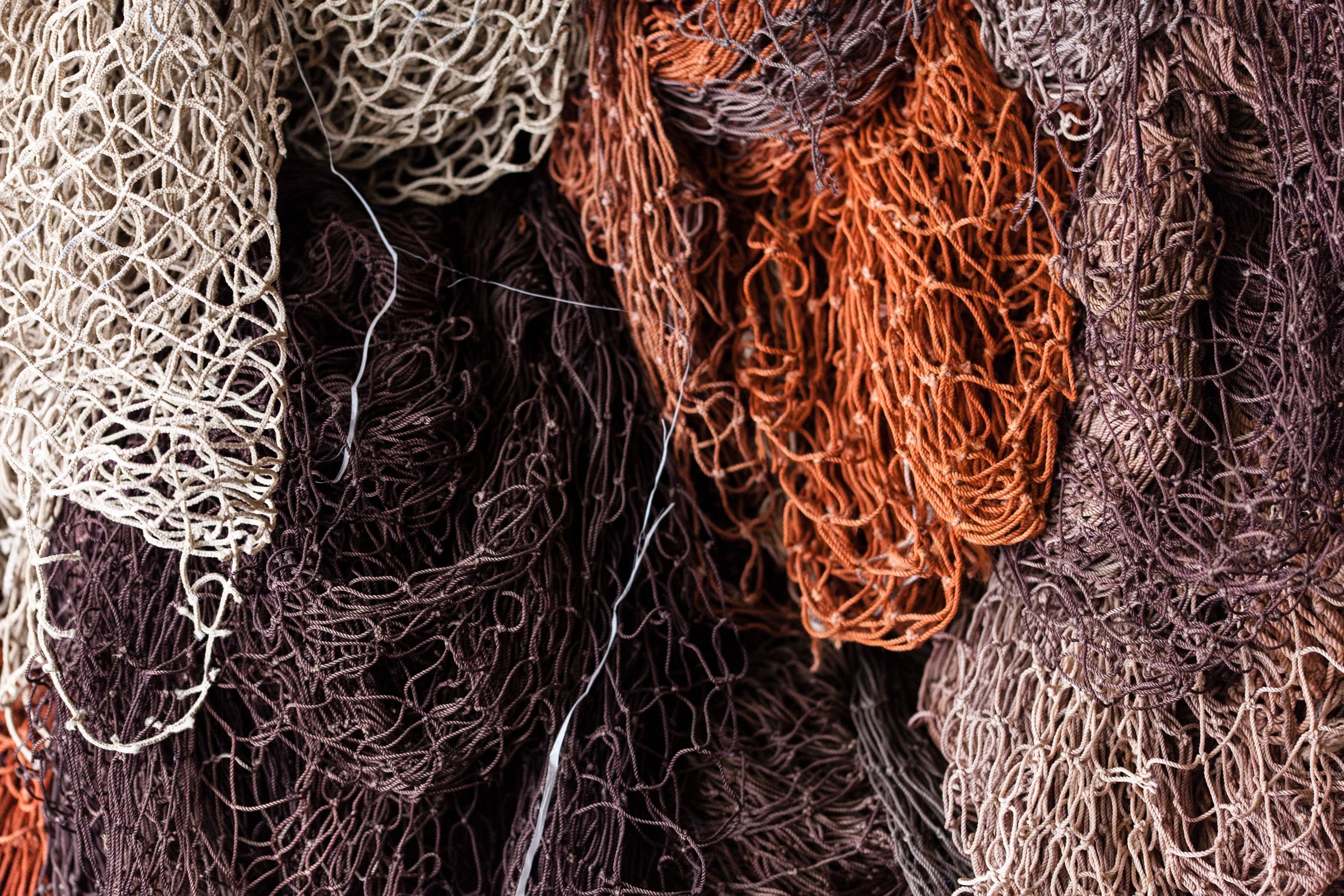 Filets de pêche usagés blanc, gris, marron et orange destinés au recyclage en ECONYL pour la fabrication de montures durables 2NDLIFE